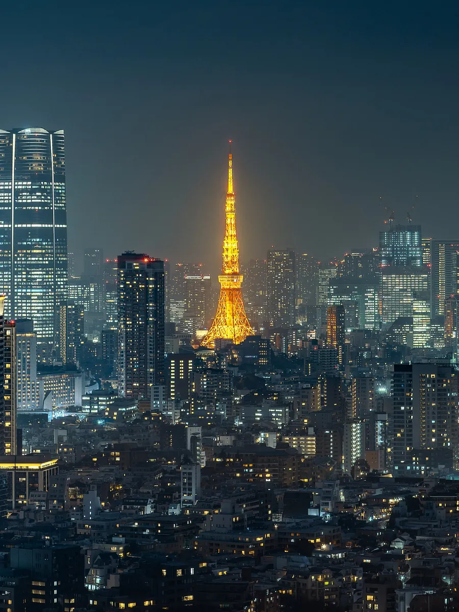 Tokyo Tower lit up at night above Minato City