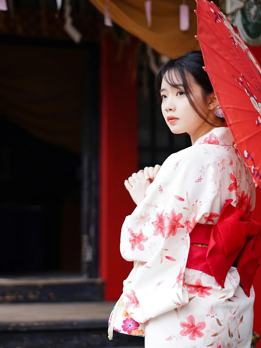 Woman in a floral kimono with a red parasol, Japan